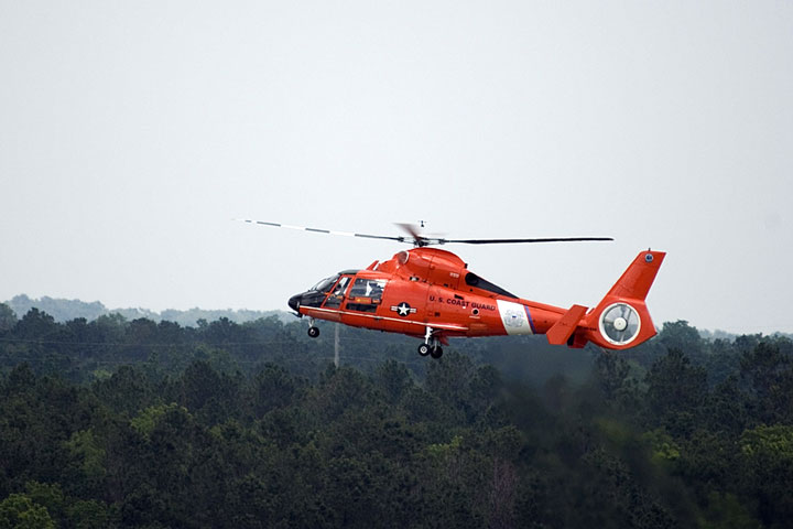 Coast Guard helicopter flying over an Alabama forest